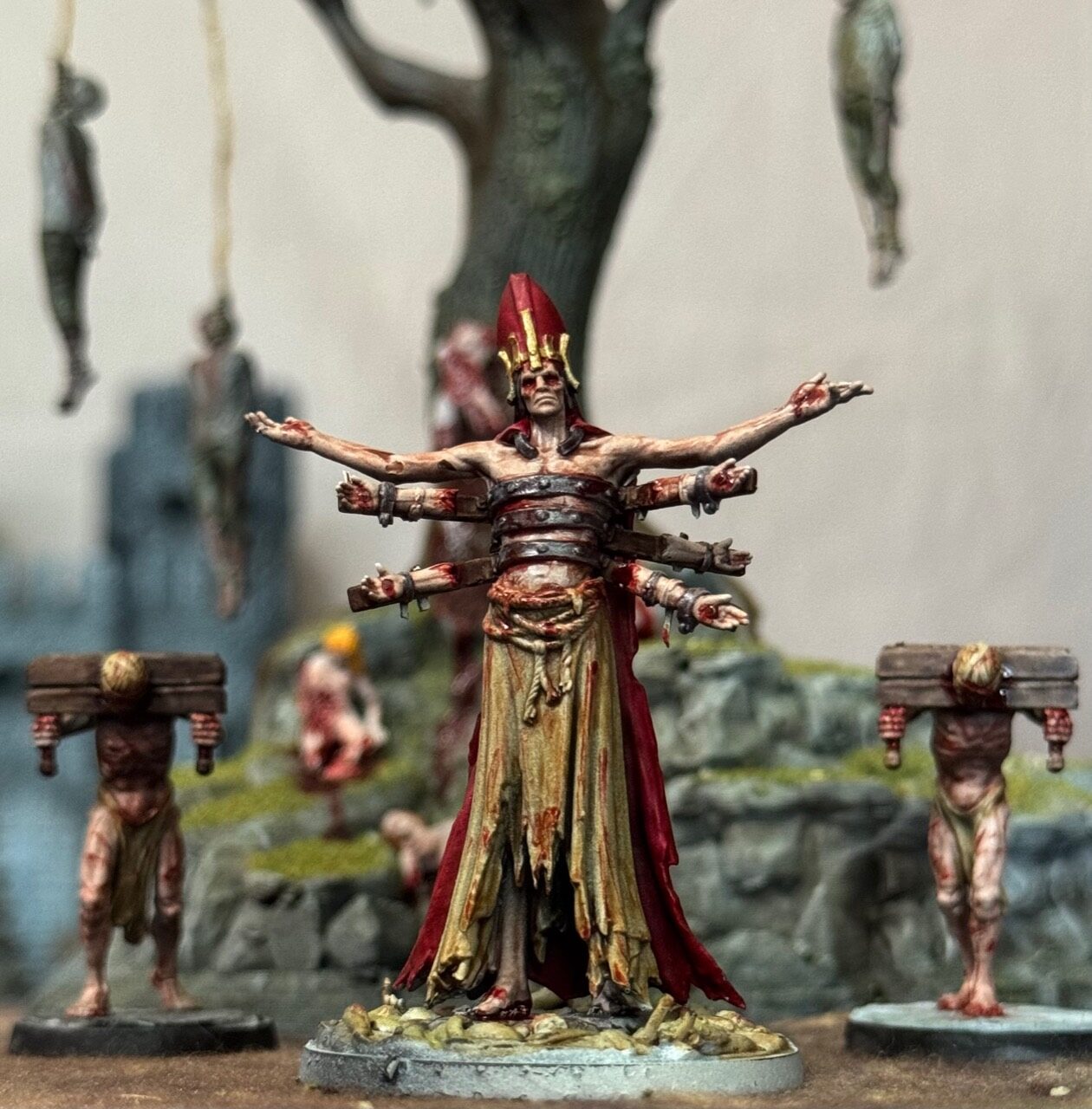 Blood-stained bishop miniature framed by hanging figures
