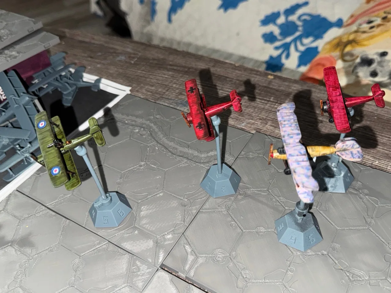 Painted aircraft on numbered HexAxis bases over grey modular battlefield tiles