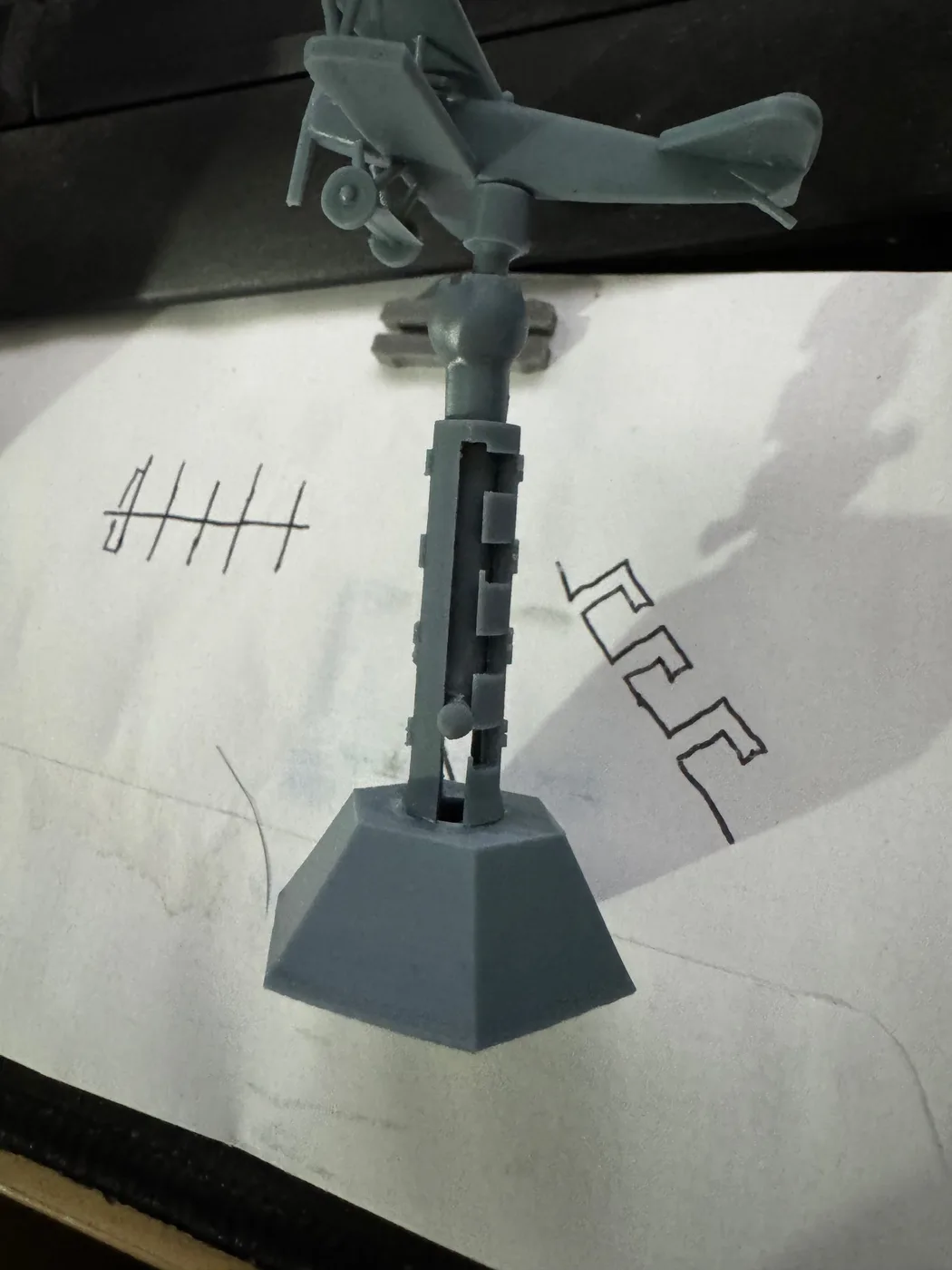 Unpainted HexAxis prototype with a faceted numbered base, upright support, and mounted aircraft