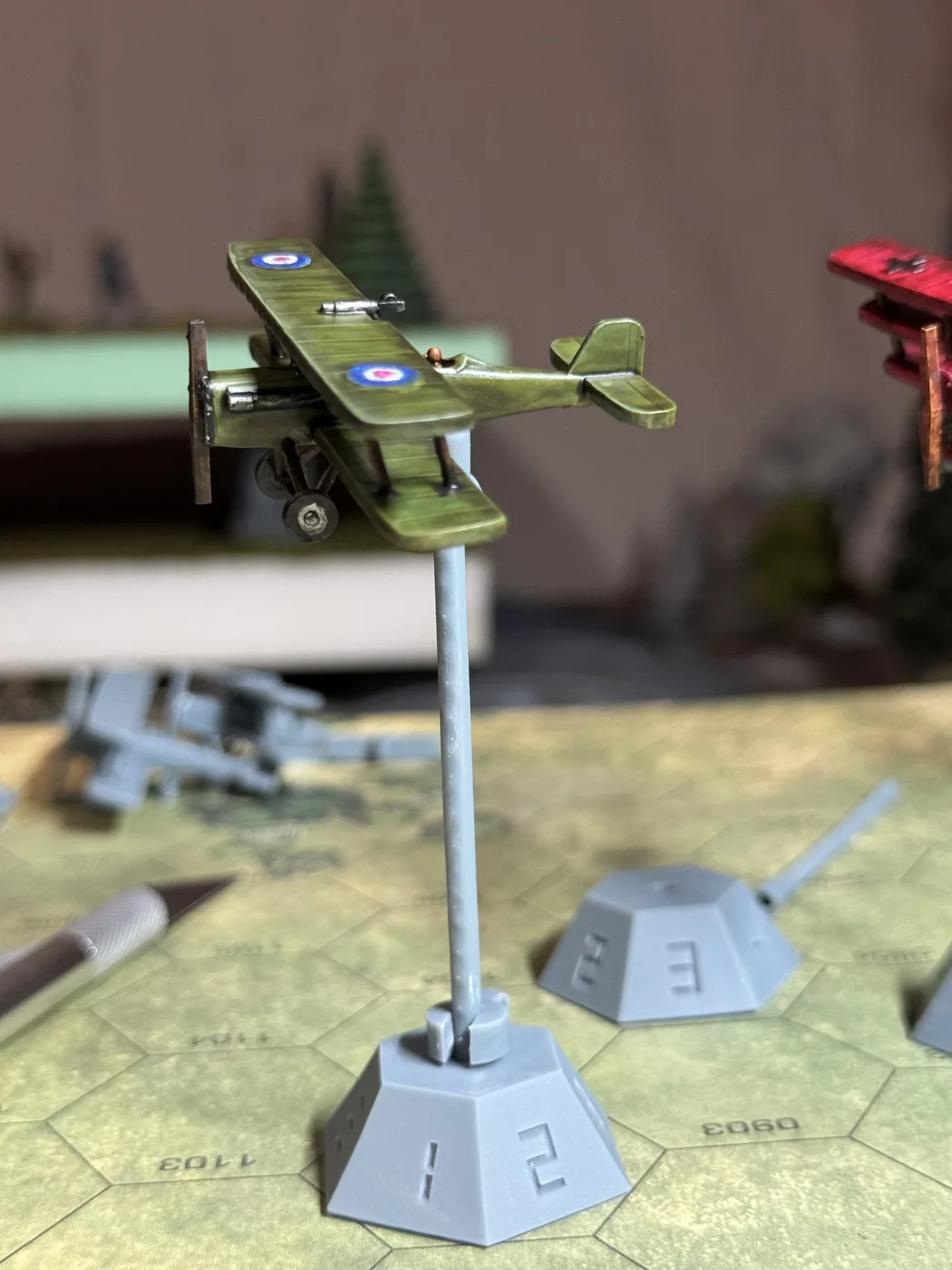 Side view of a painted green HexFlight biplane mounted on a numbered HexAxis stand