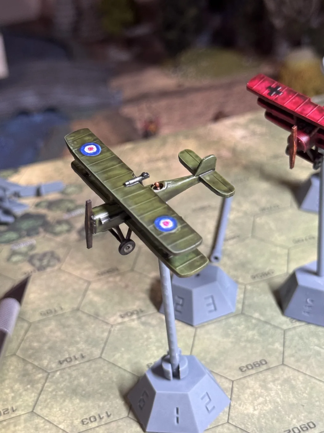 Painted green HexFlight biplane viewed from above on a HexAxis stand